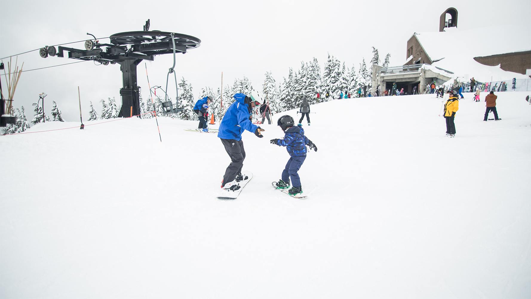 father and son snowboarding together