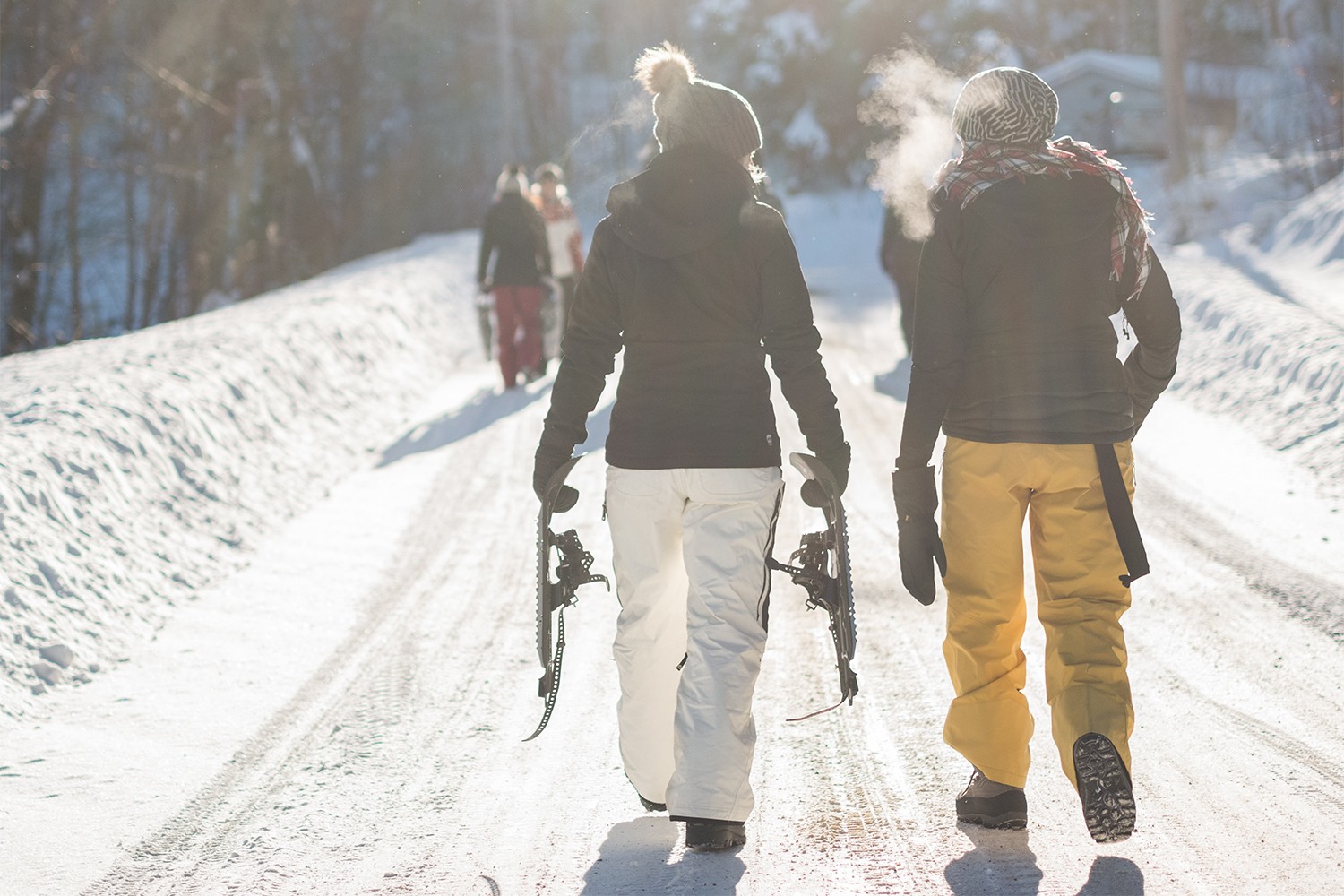 people walking while holding snowshoes